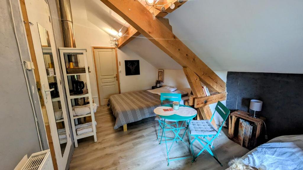 Habitación pequeña con cama, mesa y sillas en Au bon endroit -- Chambre chez l'habitant -- Via Rhona 