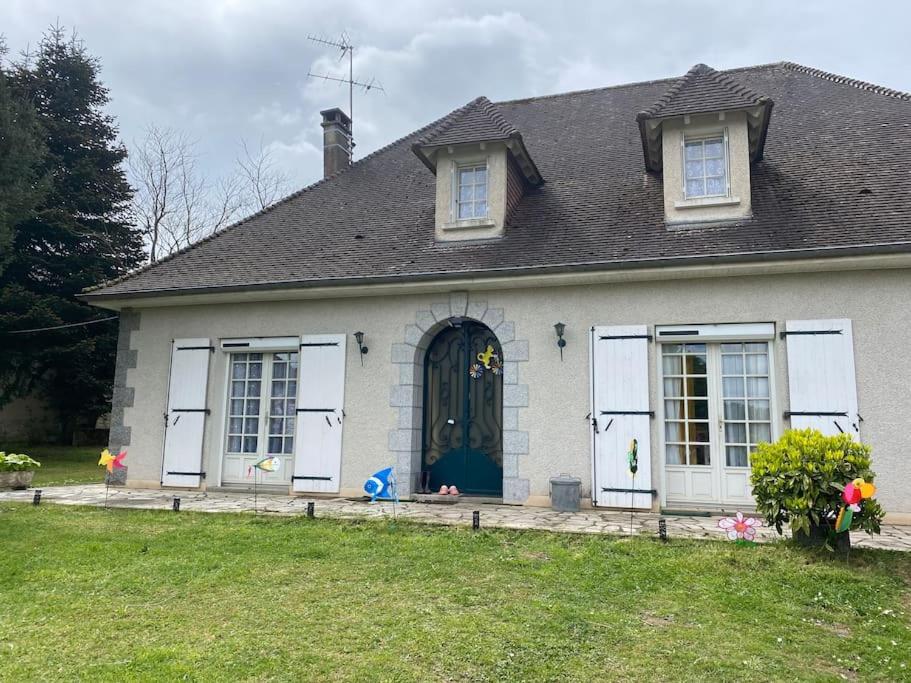 une maison blanche avec une porte noire et une cour dans l'établissement Maison périgourdine 144m2, à Piégut-Pluviers
