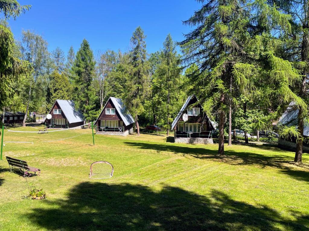 un grupo de cabañas en un parque con árboles en Ośrodek Wypoczynkowy U Dobrego Ducha en Niedzica Zamek