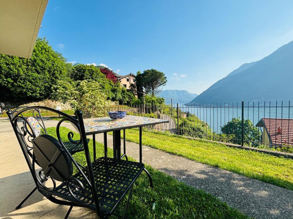 a table and chair with a view of the water at Incanto Nesso Parking and Lake View in Nesso