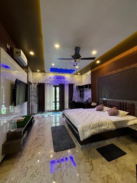 Bhoomiputra Mansion في ميسور: غرفة نوم بها سرير كبير وتلفزيون