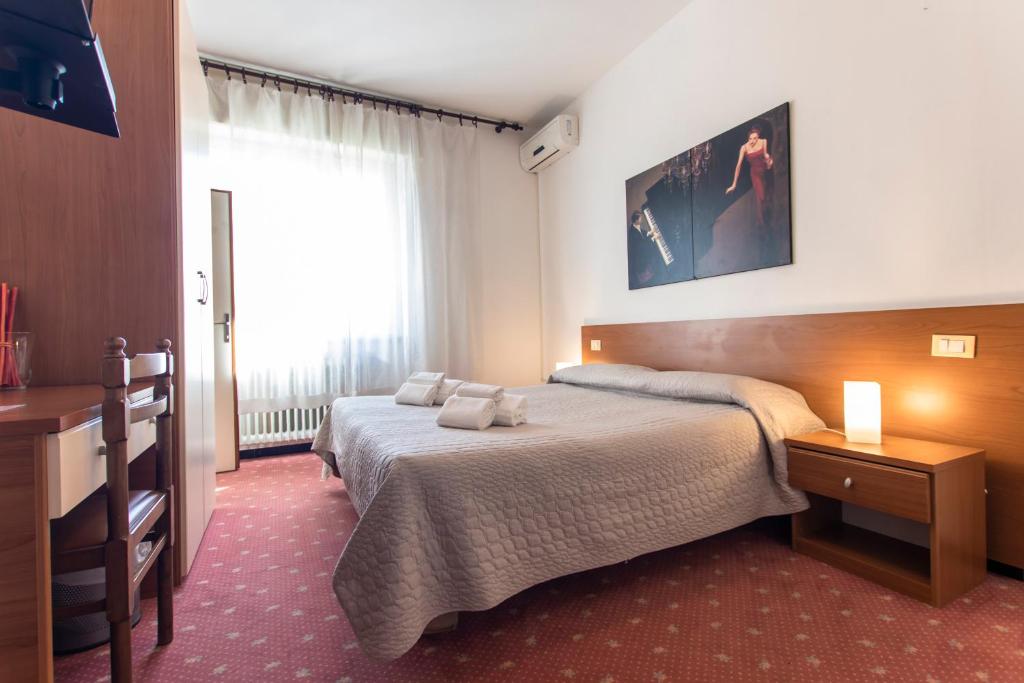 a hotel room with two beds and a window at Hotel Moranna in Lido di Camaiore