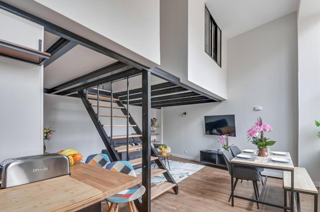 une pièce avec une table, des chaises et un escalier dans l'établissement BRP Cannes Center, Two-Bedroom Deluxe Apartment, à Cannes