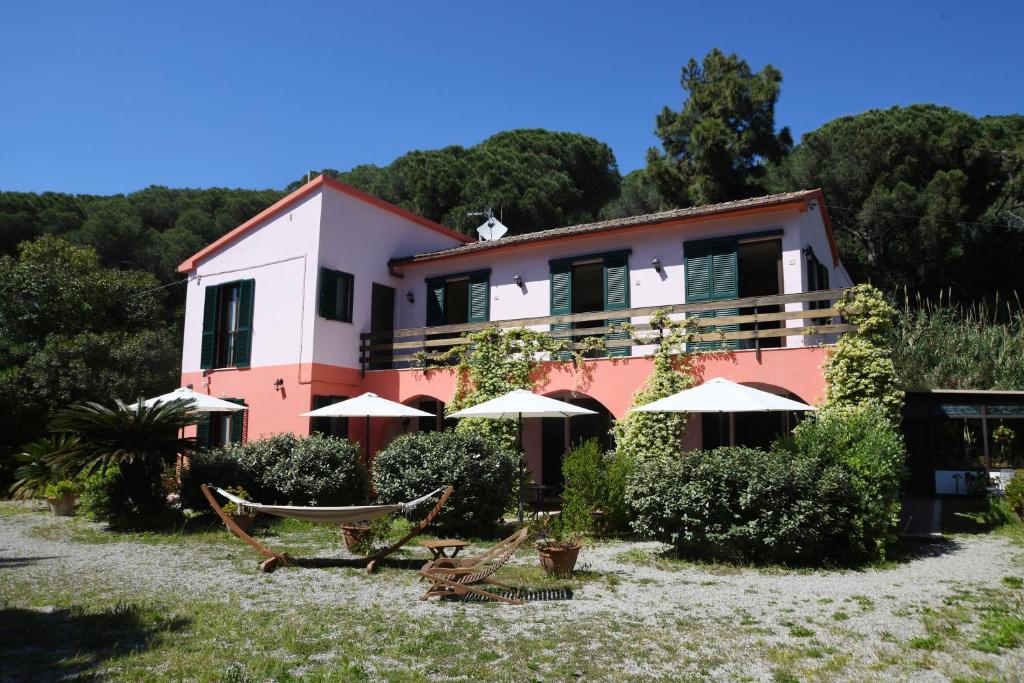 a house with chairs and umbrellas in front of it at Villa Gaia in Portoferraio