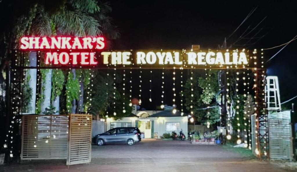 een auto geparkeerd onder een motel het koninklijke opschrift bij Shankars Motel The Royal Regalia, Bhopal in Phanda