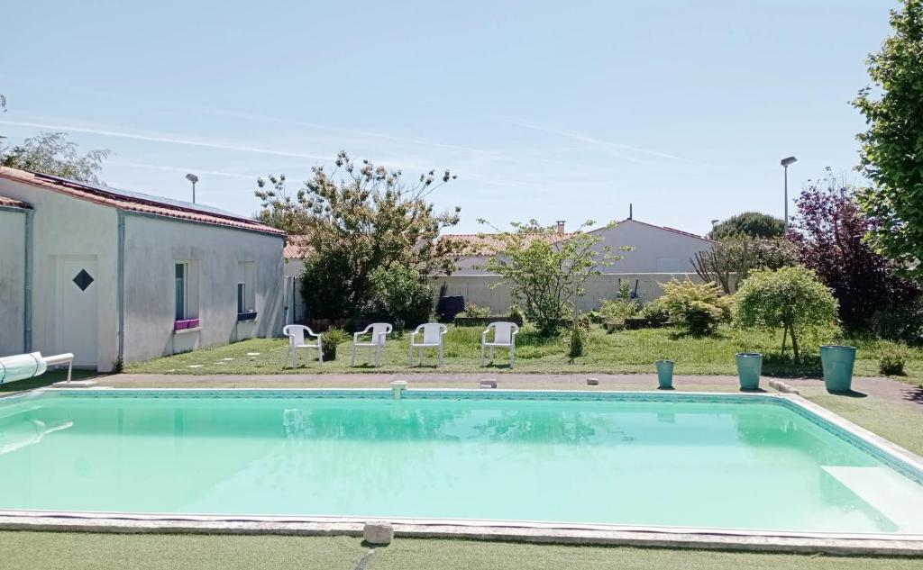 - une grande piscine avec 2 chaises dans la cour dans l'établissement Appartement de 2 chambres avec piscine partagee et wifi a La Jarrie, à La Jarrie