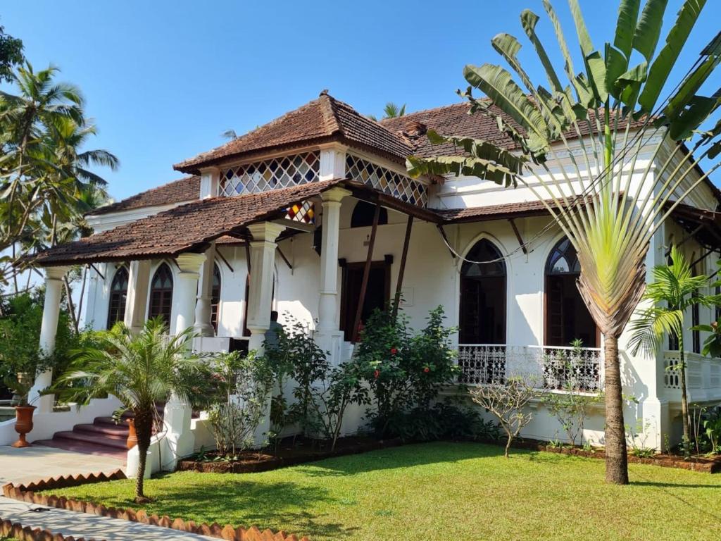 Verla的住宿－VILLA LOU GOA Heritage Portuguese House 1903 With Pool，前面有棕榈树的房子