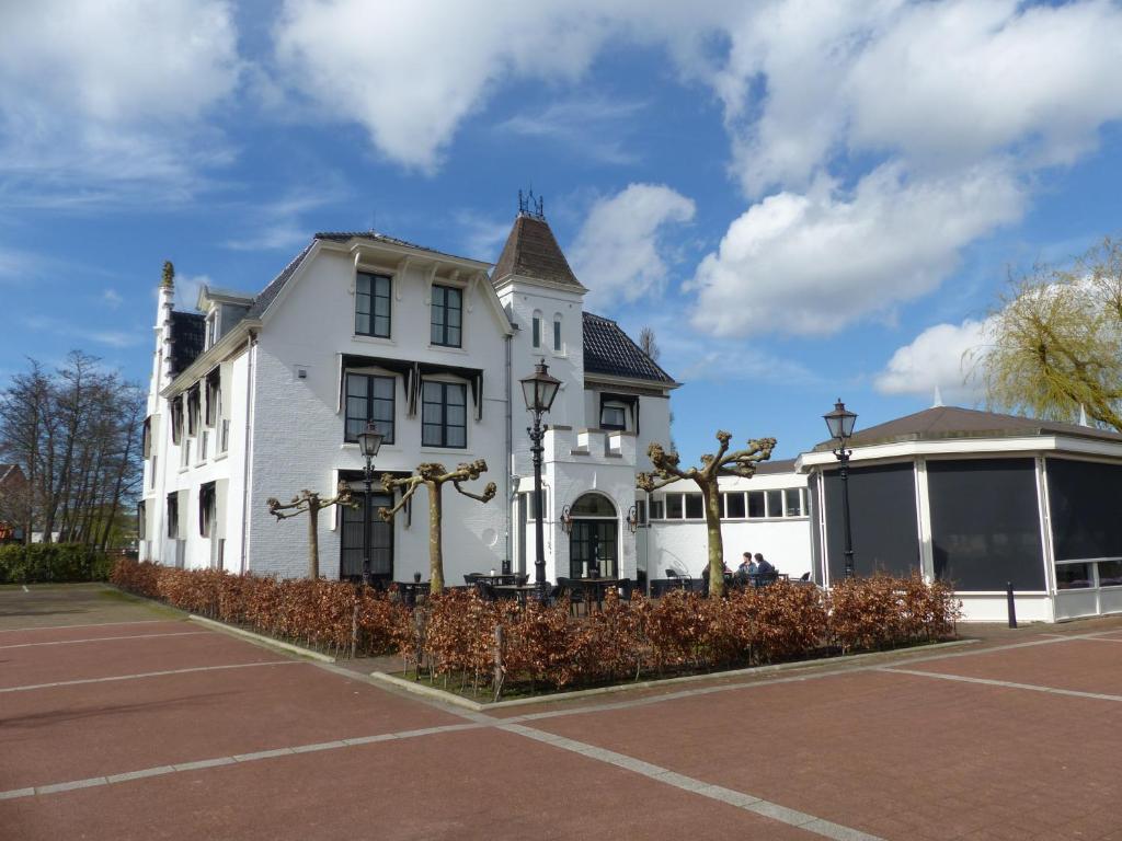 a white house with a tennis court in front of it at Herberg Welgelegen in Katwijk