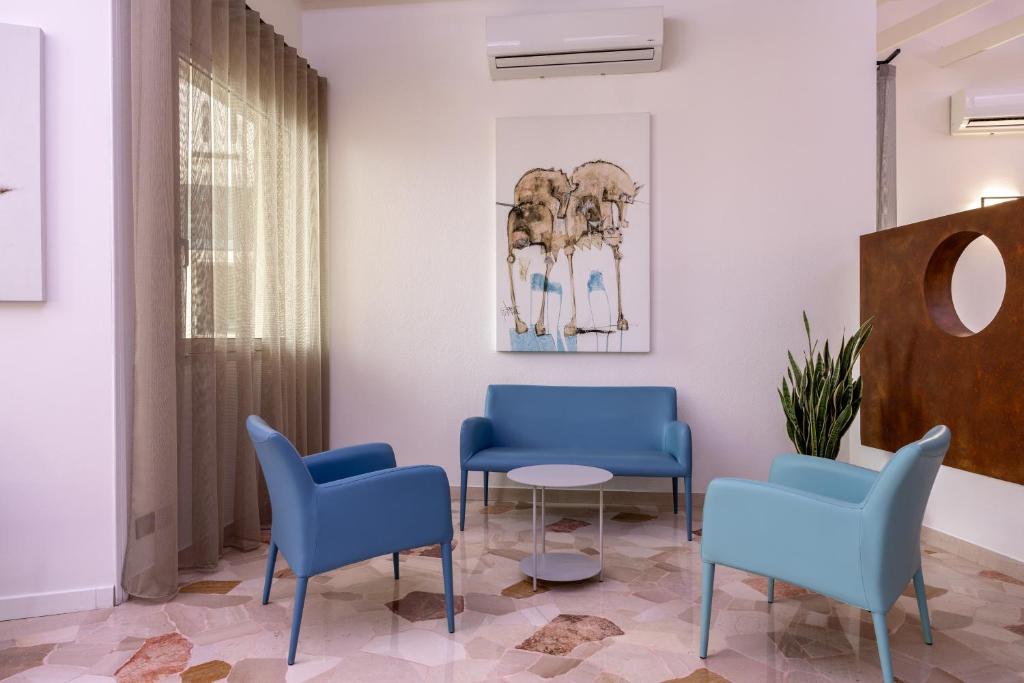 a waiting room with blue chairs and a table at Hotel Continental in Caorle