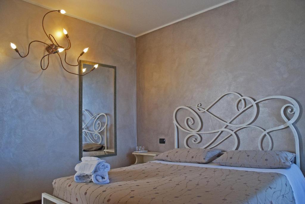 Portola la vecchia dimora في Roncola: غرفة نوم مع سرير مع مرآة كبيرة