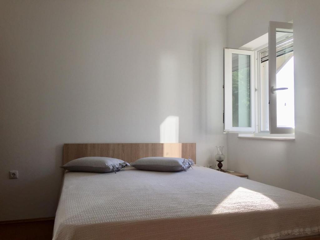 a bed in a white room with a window at Neve in Kali