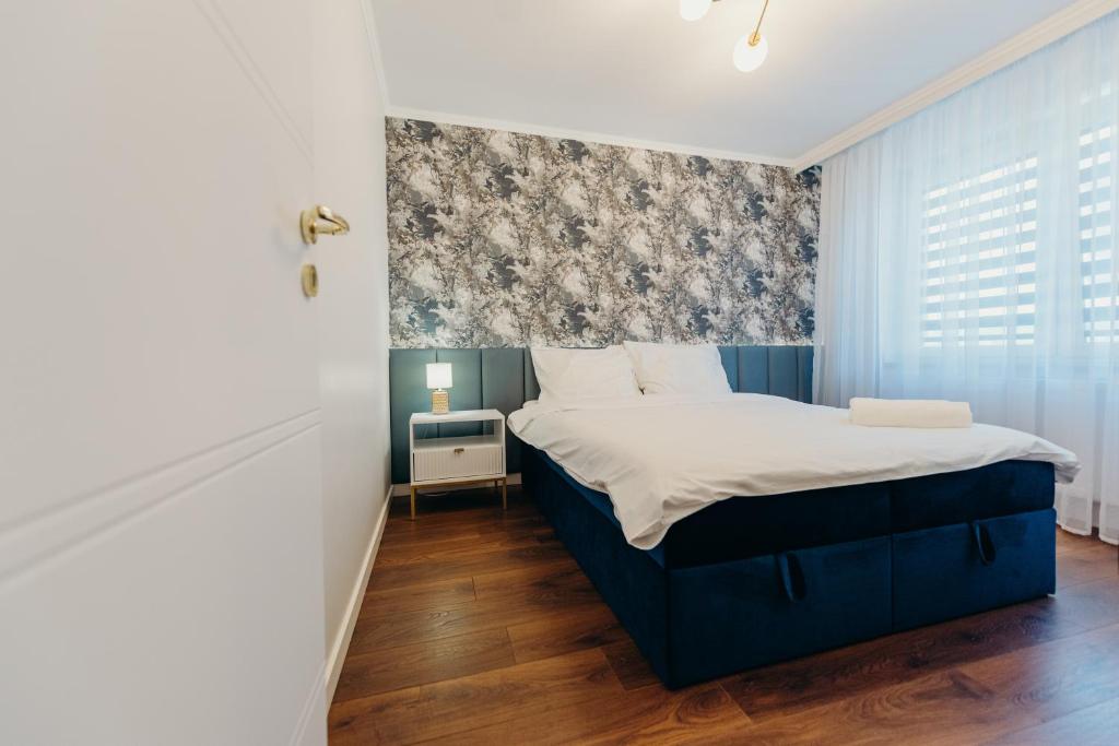 a bedroom with a blue bed with a blue and white headboard at 3 Bedrooms Premium Bella Blue for 8 Guests with AC and Free out side Parking in Rzeszów