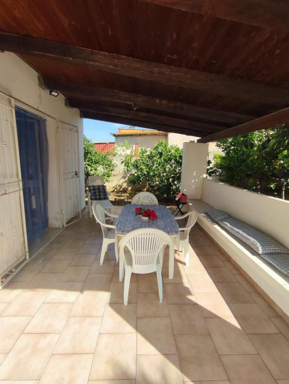 une terrasse couverte avec une table et des chaises. dans l'établissement Balestrate holiday home 70 Mq, à Balestrate