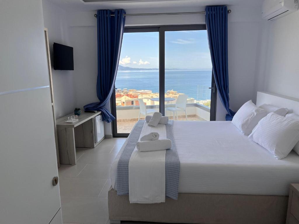 a bedroom with a bed with a view of the ocean at Sea View Hotel in Sarandë