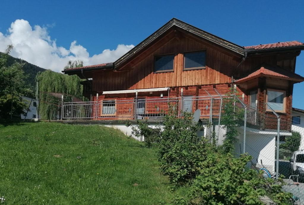 a house with a large deck on a yard at Ferienwohnung Mireille in Oberperfuss
