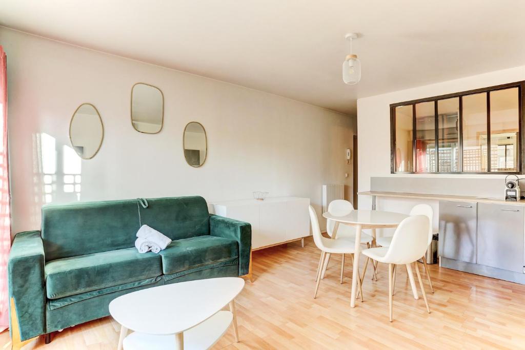 サン・シル・レコールにあるLe Cozy - Saint Cyrのリビングルーム(緑のソファ、テーブル、椅子付)