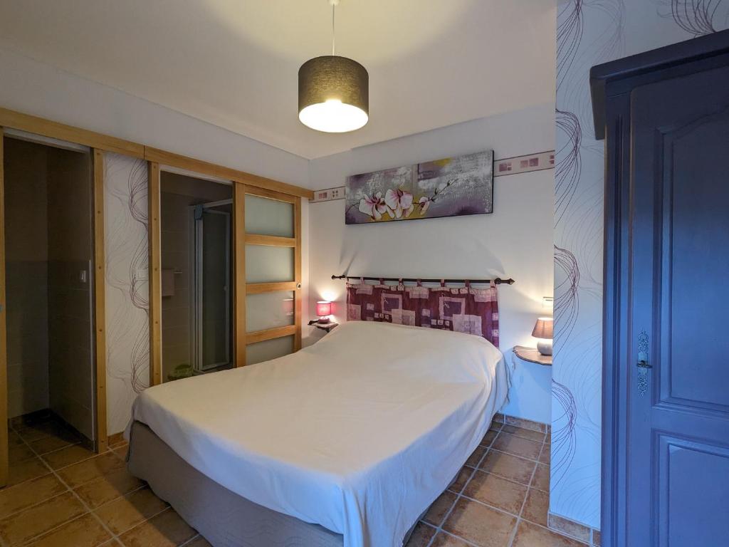 a bedroom with a white bed in a room at Chambre d'hôtes avec jardin, activités familiales et parking sécurisé au cœur du Berry - FR-1-591-448 in Vijon