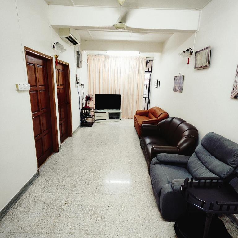 un soggiorno con un divano e una televisione di Cheras Landed Homestay 4BR - 10Pax - MRT Suntex a Cheras
