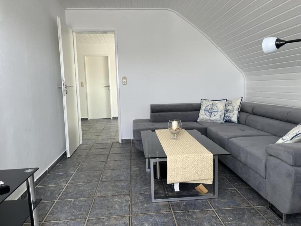a living room with a couch and a table at NEU! Ferienwohnung Up de Warf in Dornum