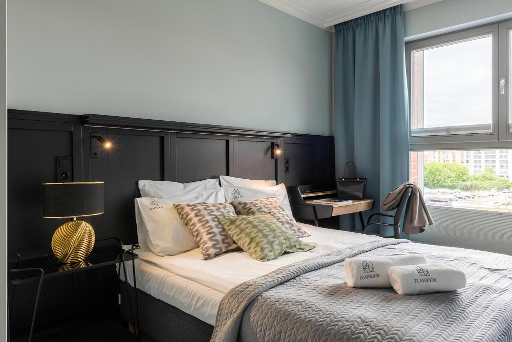a bedroom with a large bed with pillows on it at City Center Apartments Grano Residence in Gdańsk