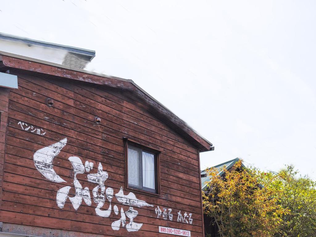 a building with white graffiti on the side of it at くぶむ荘 in Shimoyatori