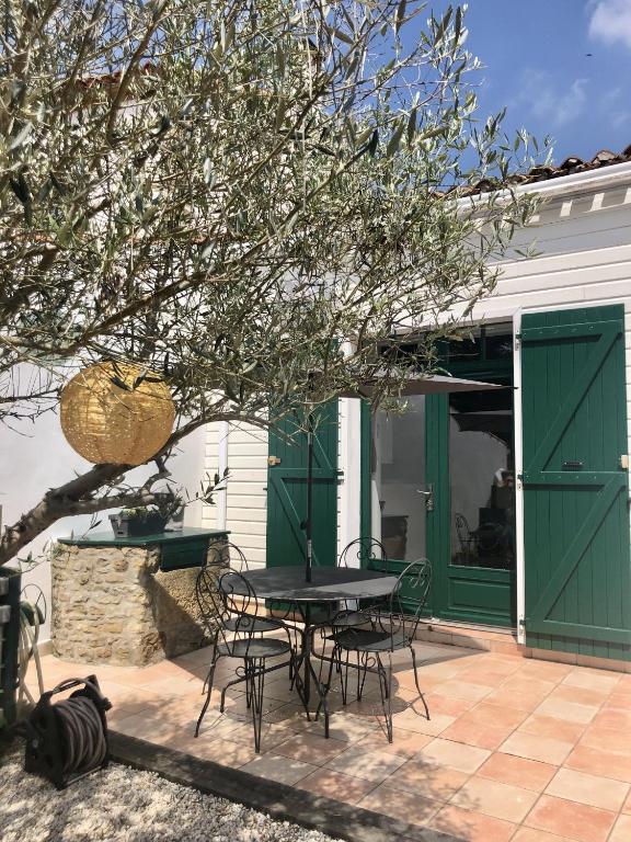 un patio avec une table et des chaises devant une maison dans l'établissement Maison de village au coeur de Talmont St Hilaire, à Talmont-Saint-Hilaire