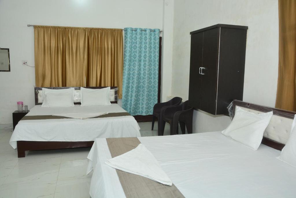 Habitación de hotel con 2 camas y ventana en Hotel Chandrasha Villa, en Ayodhya