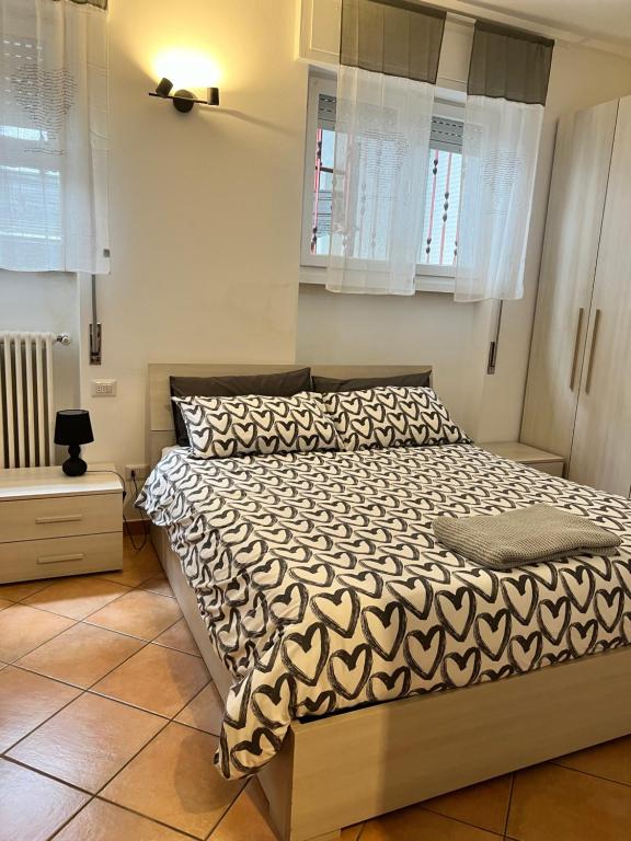 Schlafzimmer mit einem Bett mit einer schwarzen und weißen Bettdecke in der Unterkunft 85 mjka house free parking in Albese Con Cassano