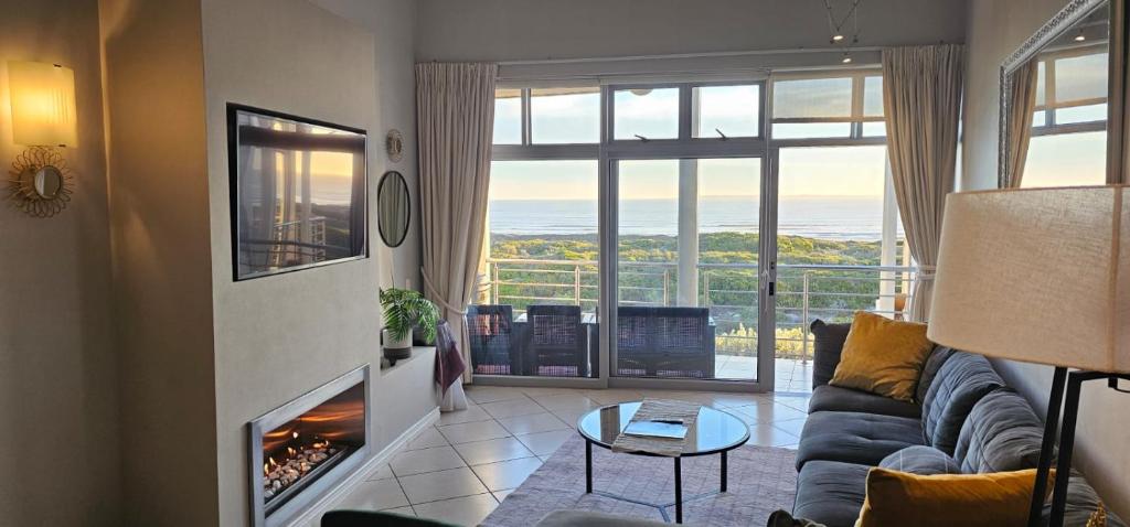 sala de estar con sofá y chimenea en Beachfront 3-bedroom with Robben Island views en Ciudad del Cabo