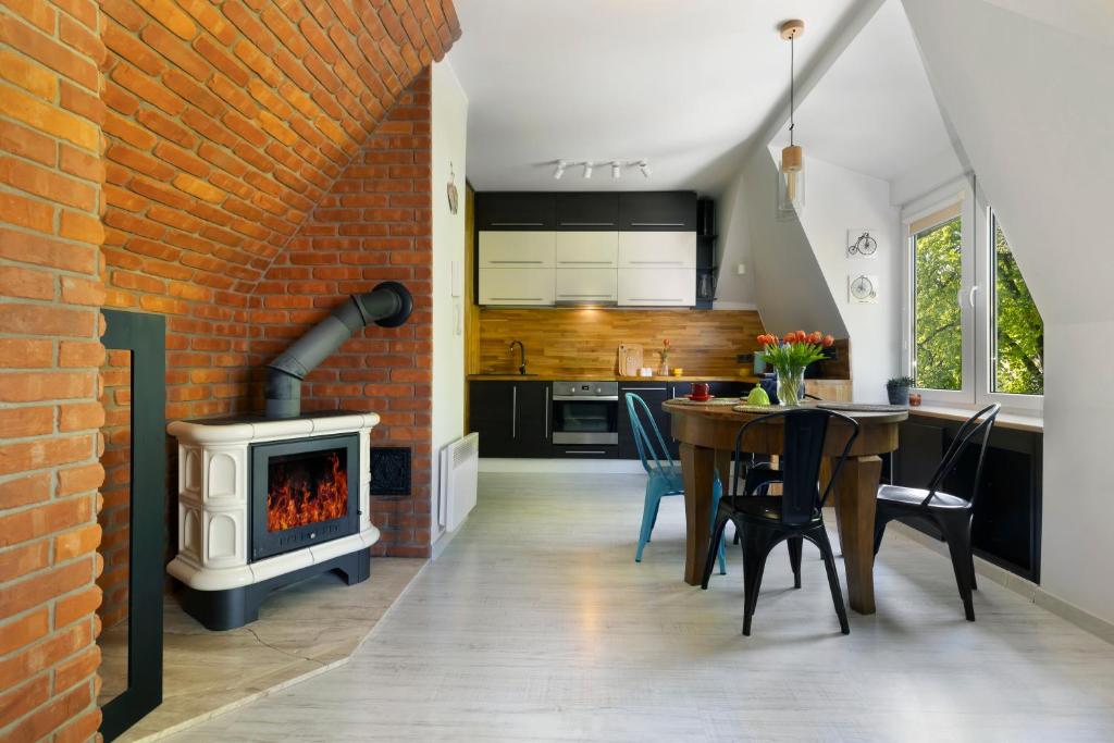 a kitchen and dining room with a brick wall at Elite Apartments City Center Cosy Attic in Gdańsk