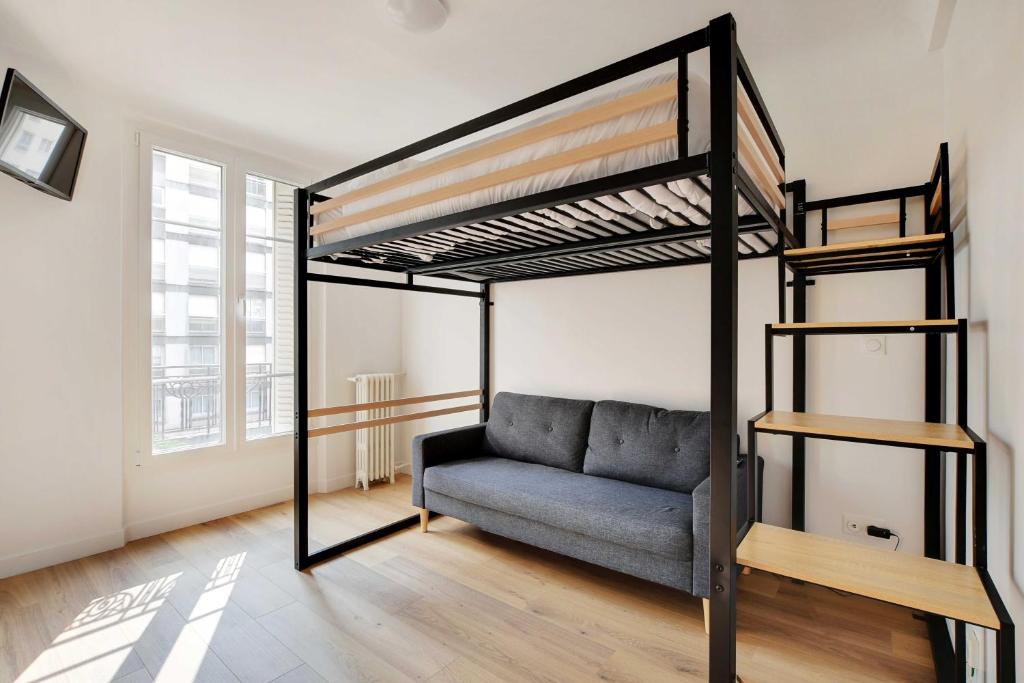 - un salon avec une mezzanine et un canapé dans l'établissement Cozy studio - 2P - Grenelle-Eiffel Tower, à Paris