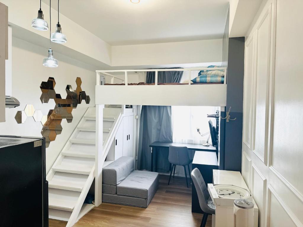 a bunk bed in a small room with a desk at "Stylish Loft Condo with High-Speed WiFi at Avida Towers" in Davao City