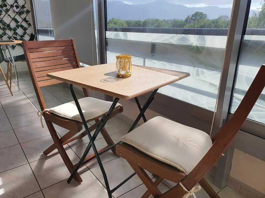 - une table avec deux chaises et un vase dans l'établissement Caravelle T1 lumineux au calme à 5 mn de la mer, à Argelès-sur-Mer