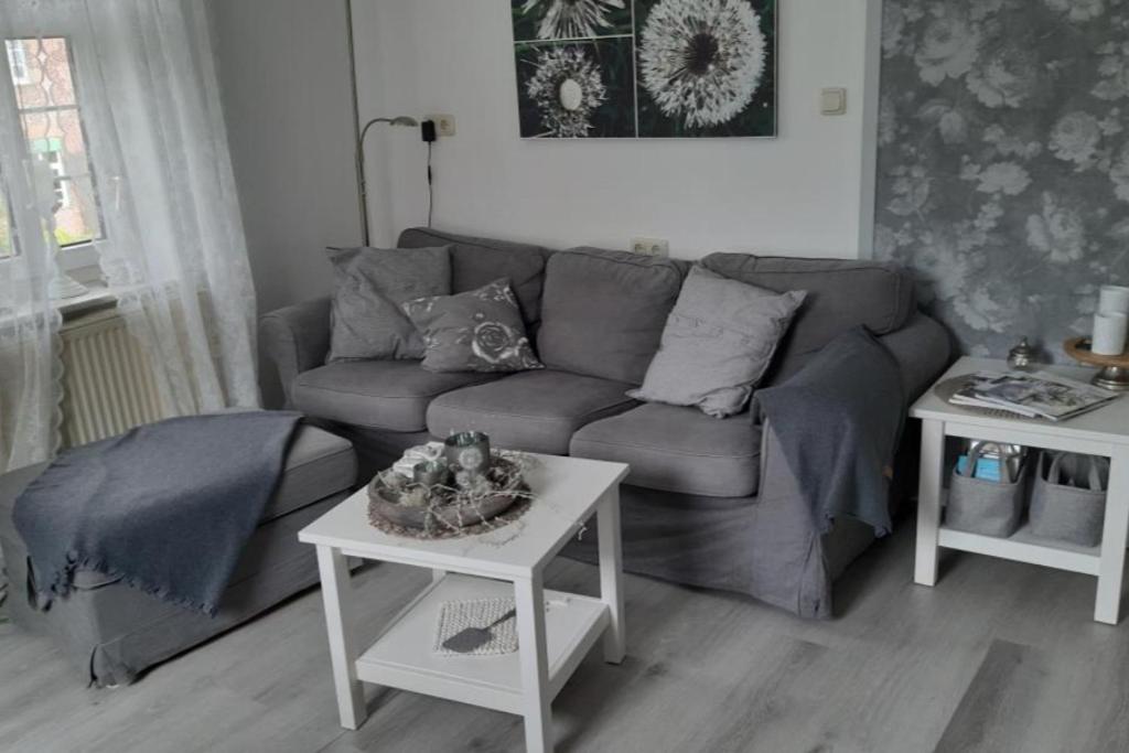 a living room with a couch and a table at NEU! Ferienwohnung Zur Pusteblume in Sande