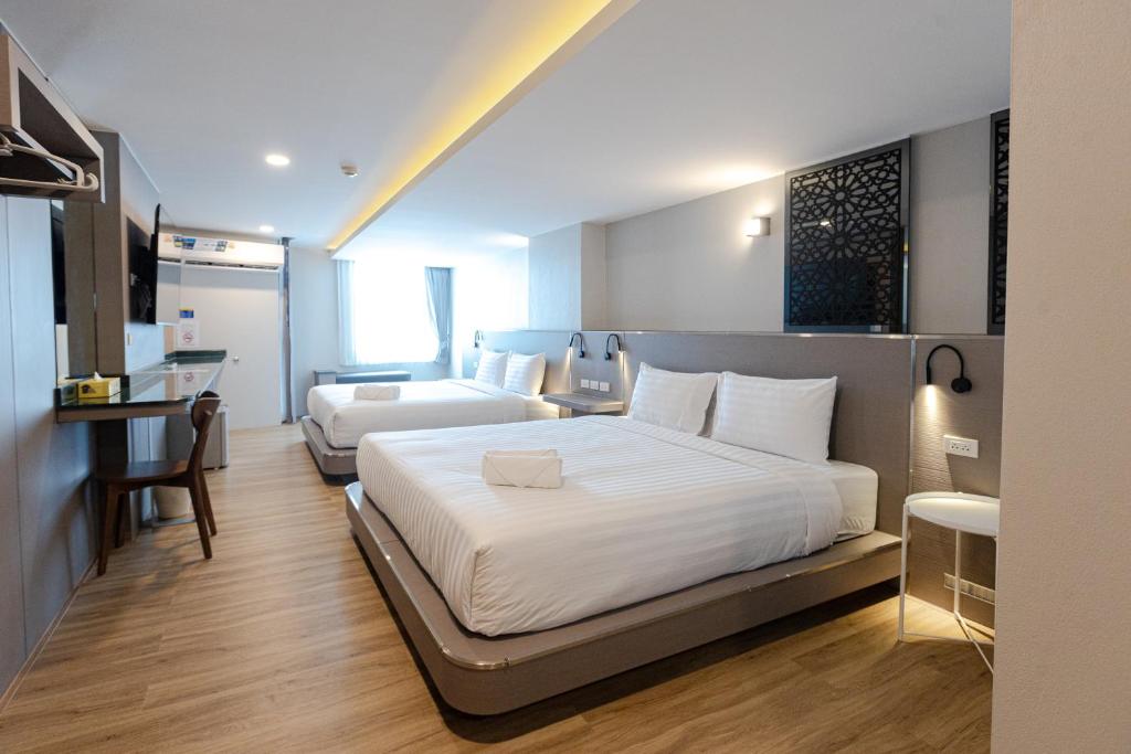 Habitación de hotel con 2 camas y escritorio en วัน บัดเจท ตาก แม่สอด - One budget hotel Tak Maesot en Mae Sot