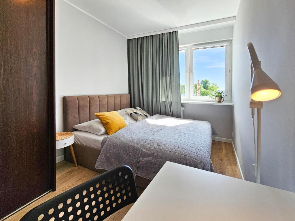 niewielka sypialnia z łóżkiem i oknem w obiekcie visit baltic - Green Apartment - Chrobrego 02 w Świnoujściu