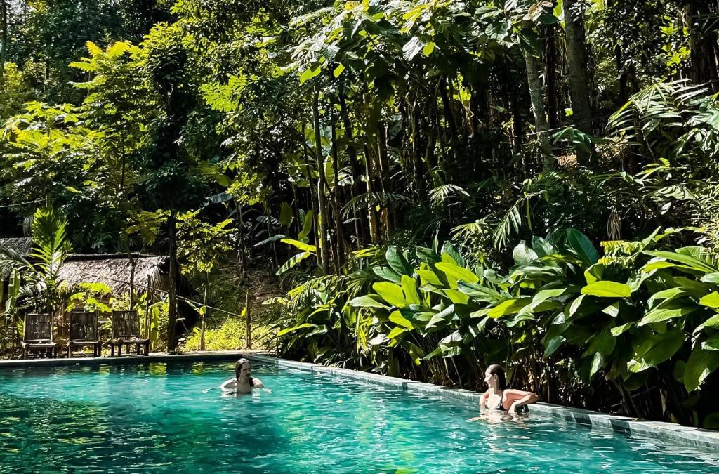 duas pessoas numa piscina na selva em PU LUONG BOUTIQUE GARDEN em Pu Luong