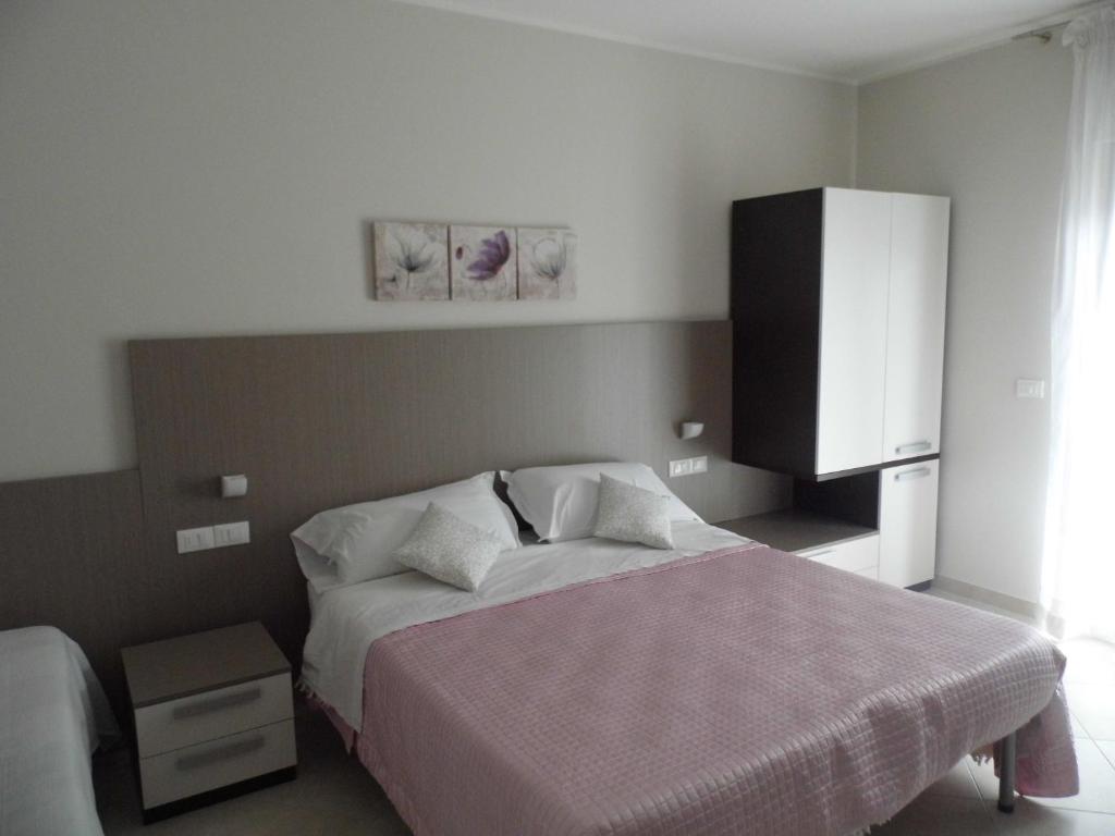 ペスカーラにあるAppartamento Orchideaのベッドルーム1室(大型ベッド1台、白いキャビネット付)