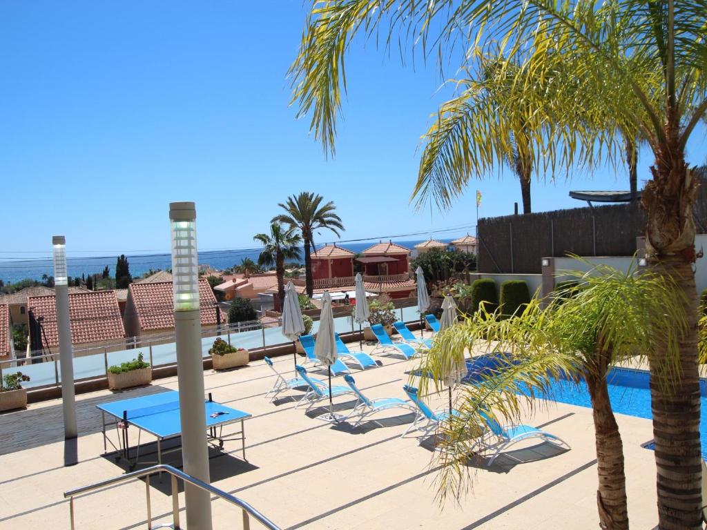 a row of lounge chairs and a pool at a resort at Cristinas Villa-New 5-Bedroom Chalet with Pool, En-Suite Baths & Exceptional Amenities Near the Beach in Bolnuevo