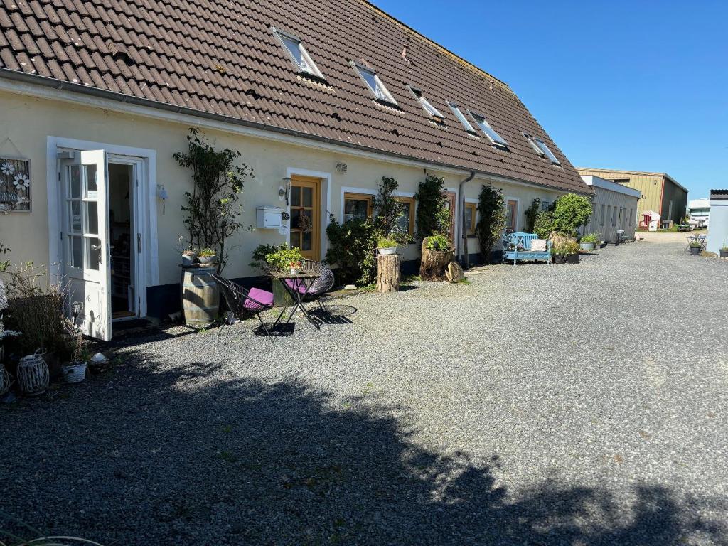 a white house with a roof and a gravel driveway at Strandhof Holnis in Glücksburg