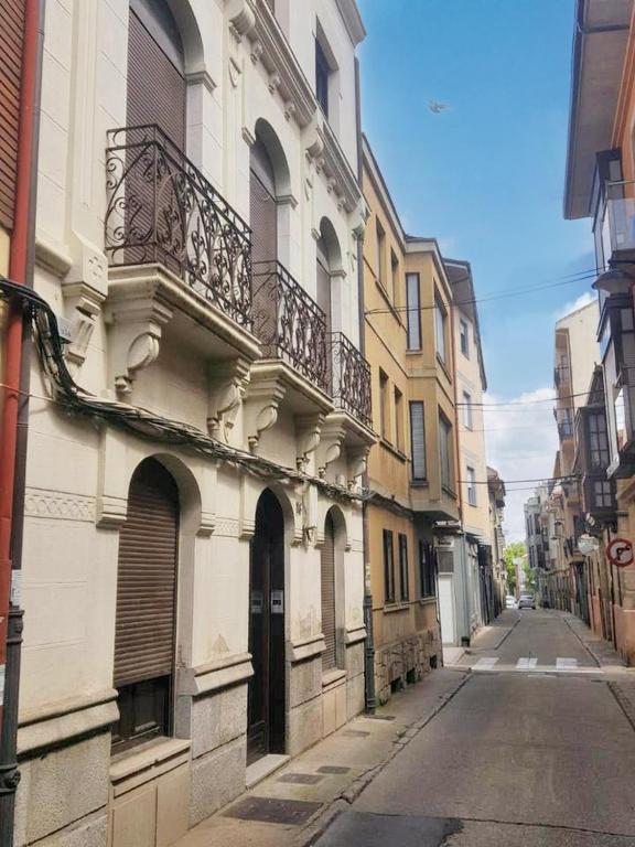une rue vide avec un bâtiment doté d'un balcon dans l'établissement 3 bedrooms apartement with furnished terrace and wifi at Astorga, à Astorga
