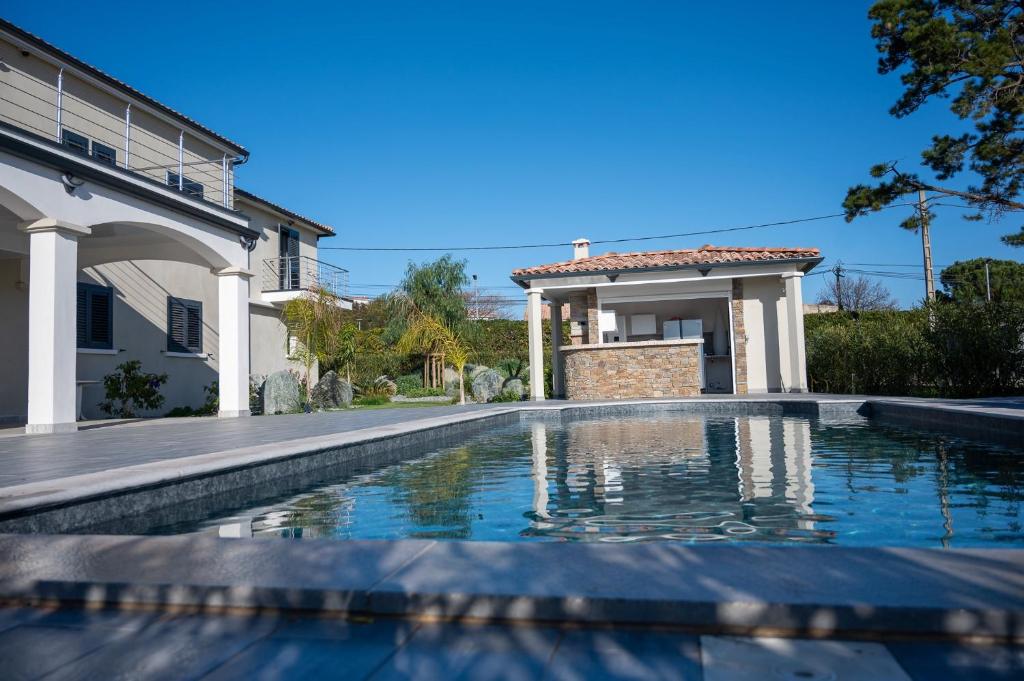 una piscina frente a una casa en Rez de maison neuve Piscine WiFi Poolhouse en Pierre, en Penta-di-Casinca