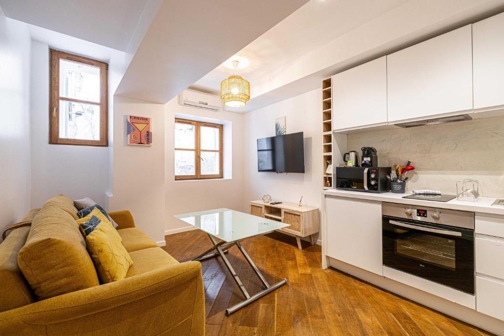 Il dispose d'une cuisine et d'un salon avec un canapé et une table. dans l'établissement Renovated apartment - Cannes Meynadier, à Cannes