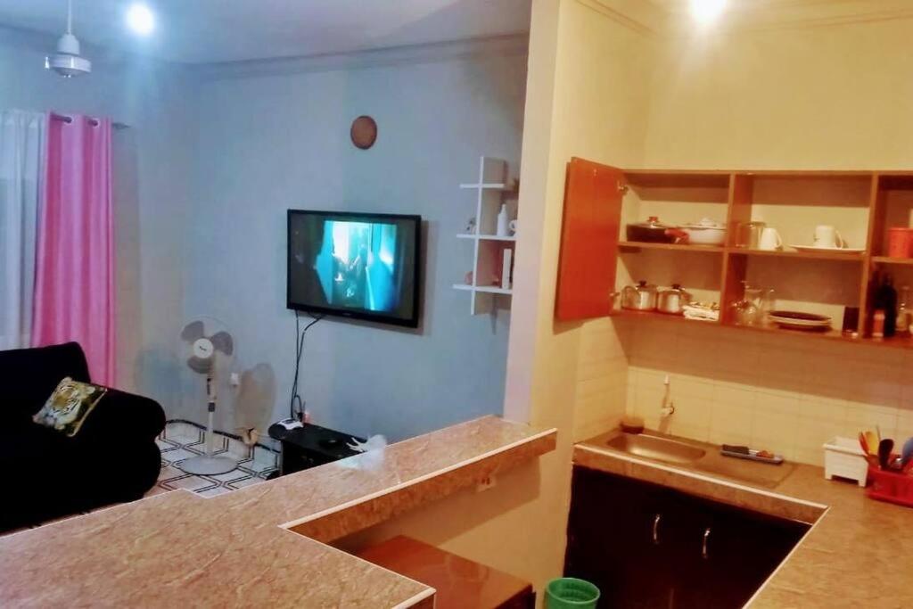 uma sala de estar com uma televisão na parede em shiks appartment em Melinde