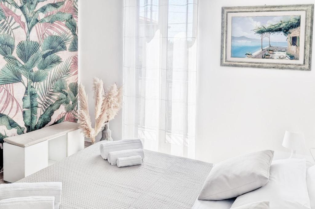 biała sypialnia z białym łóżkiem i obrazem na ścianie w obiekcie IL MELOGRANO RESIDENCE MARZAMEMI w mieście Marzamemi
