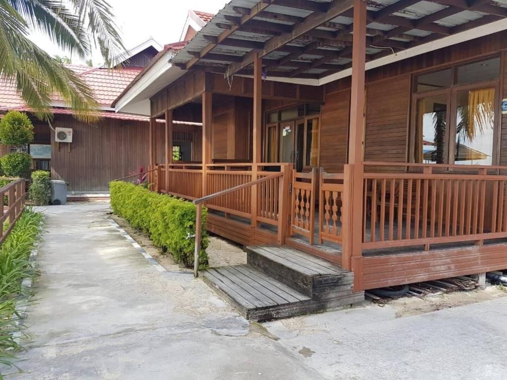 a wooden house with a porch and stairs to it at Derawan Beach Cafe and Cottage in Derawan Islands