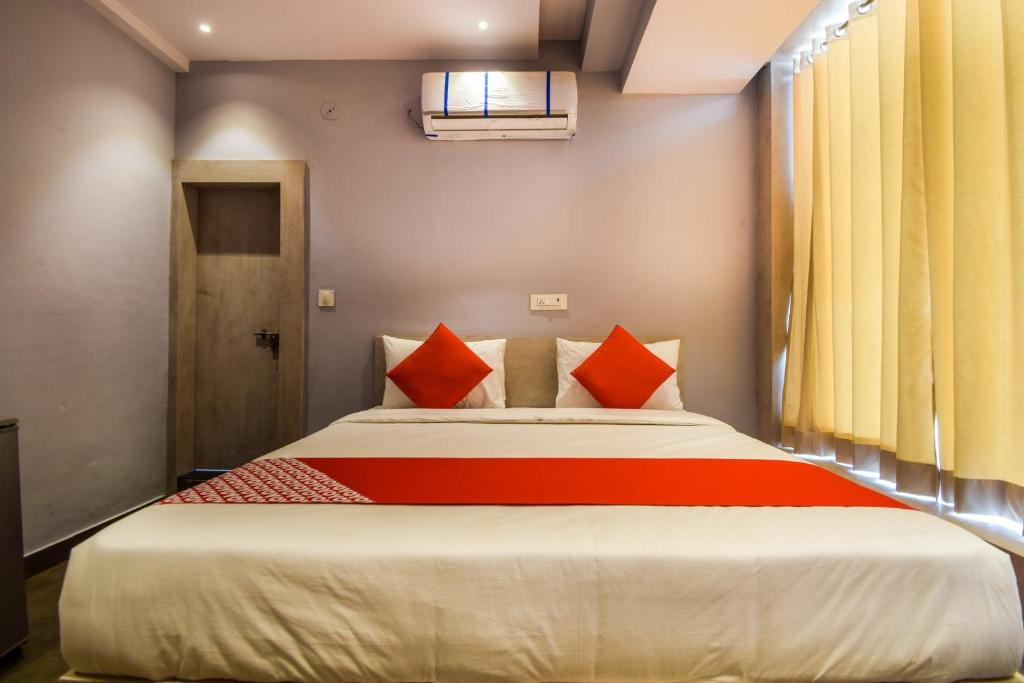 a bedroom with a large bed with orange pillows at Hotel Kanchan Residency in Kota