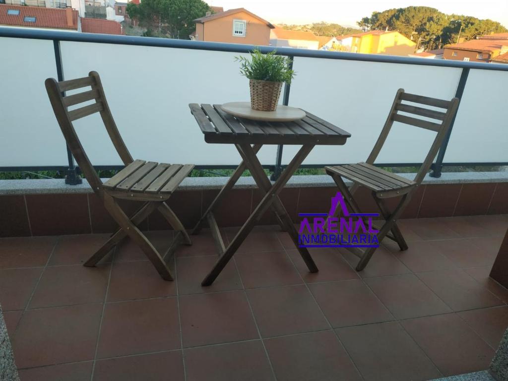 einen Tisch und zwei Stühle auf dem Balkon in der Unterkunft O Faro, a 150 mtrs de playa Corna in San Pedro