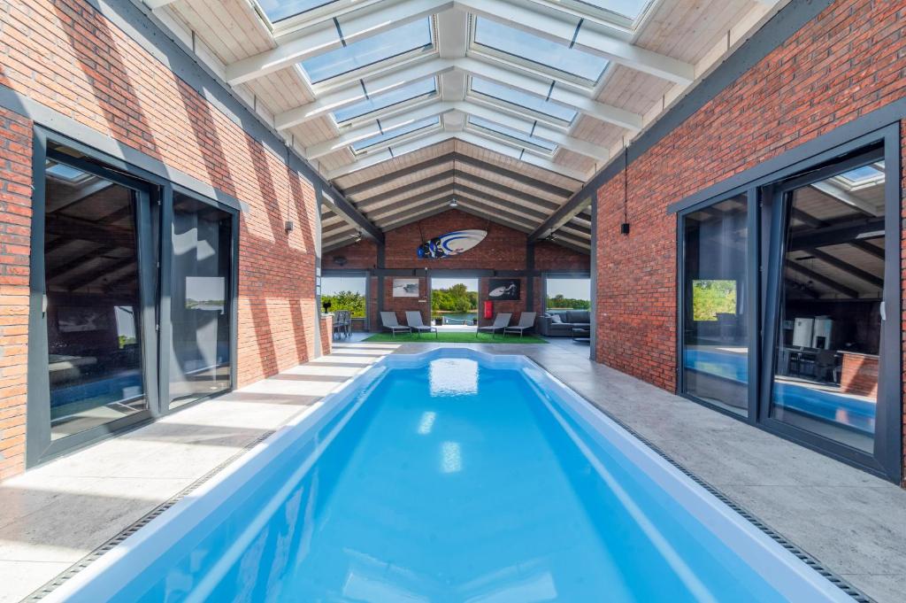 an indoor swimming pool in a brick building with a ceiling at NGlamping in Chełmża