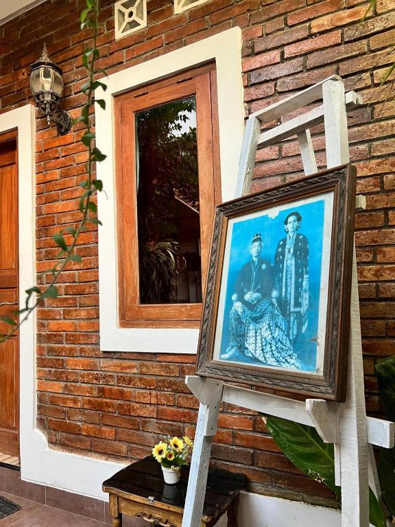 a picture on a ladder in front of a house at Rumah Pathuk Syariah Homestay in Yogyakarta